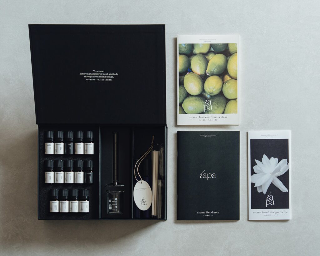 精油、ガラスのビーカー、ムエットなどが入っているアロマ調香ボックス、テキスト、アロマ調香ノート