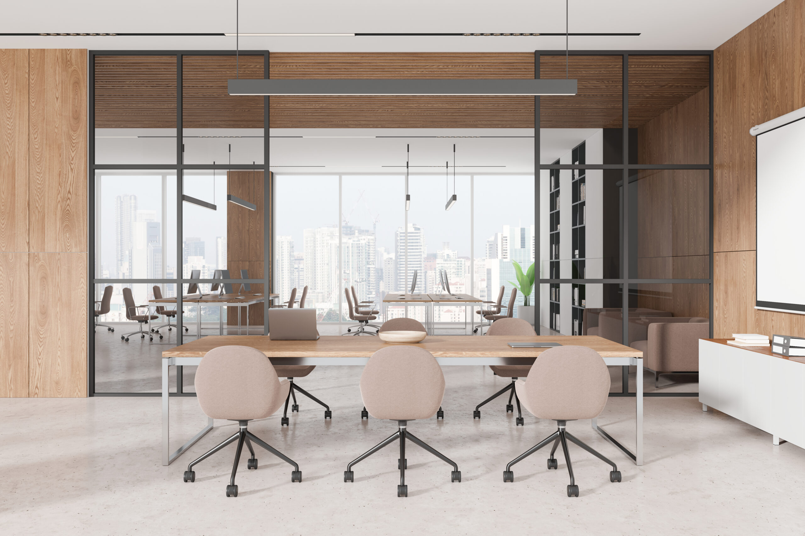 大きな窓に面したオフィスの写真。大きなデスクと椅子。